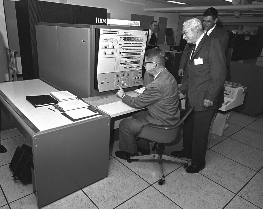 U.S. Department of Agriculture (USDA) Statistical Reporting Service (SRS) Administrator Harry Trelogan looks on as Agriculture Secretary Orville Freeman tests out some of the functions of the IBM 360 computer. The Washington Data Processing Center officially opened on April 1, 1966 and uses the new IBM 360 computer to process data for all U.S. Department of Agriculture (USDA) agency programs. Photo courtesy of the National Archives and Records Administration. Note: This is a Model 40.