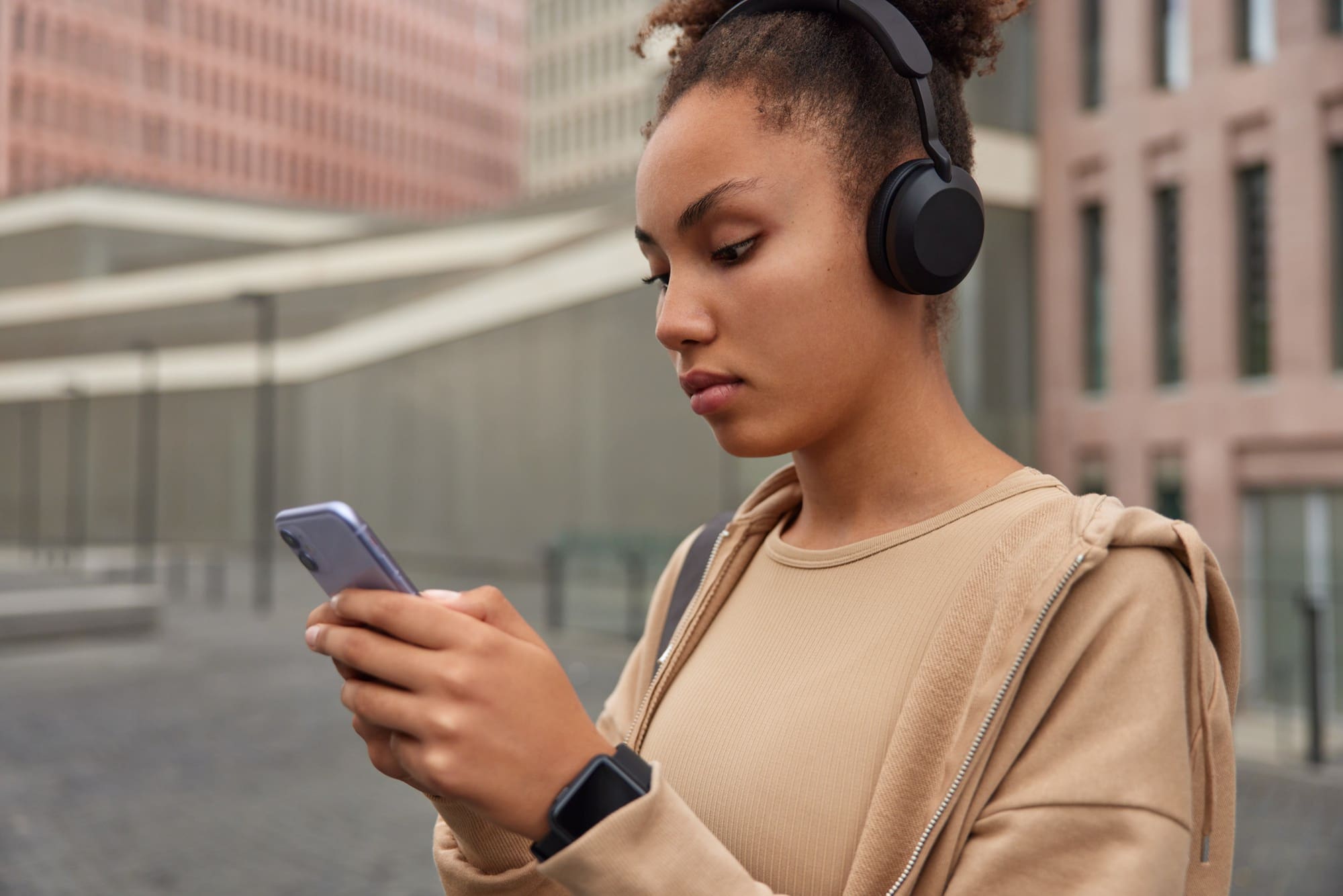 Girl is pairing wireless headphones to phone via bluetooth